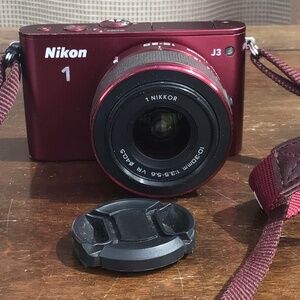 Burgundy Red Nikon 1 J3 high-speed camera with two lenses